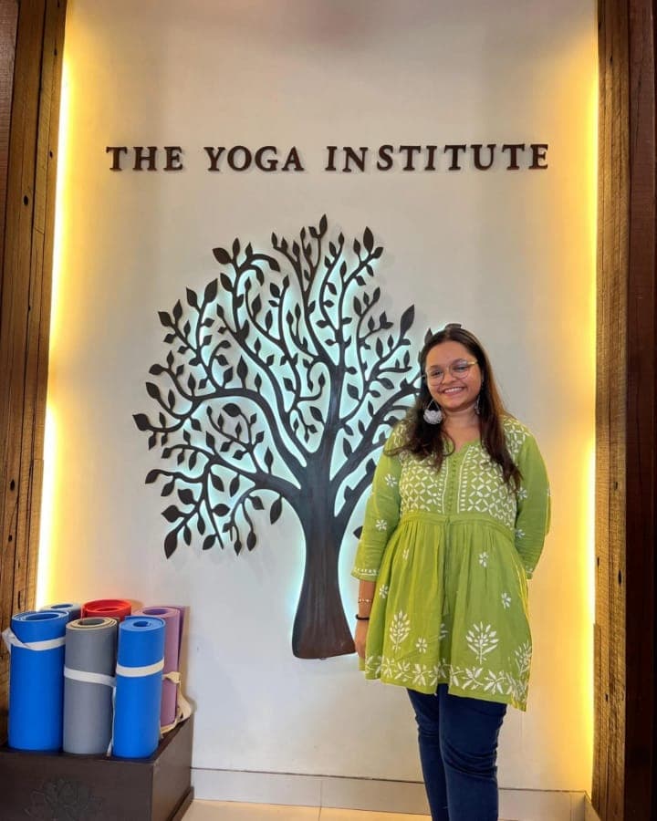 Irika Goyal standing in front of The Yoga Institute sign